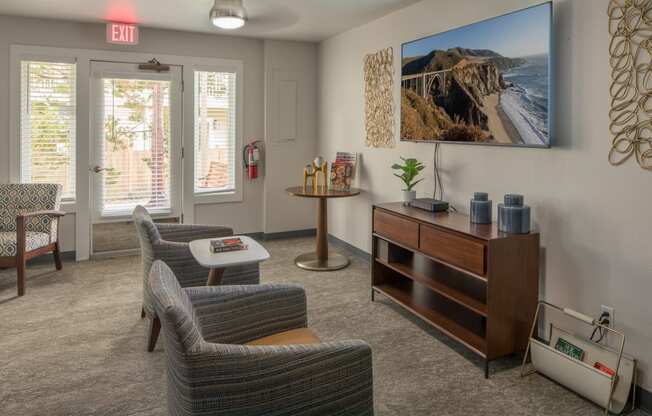 a living room with chairs and a table and a television