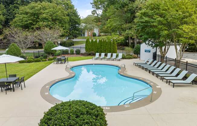 a swimming pool with lounge chairs and umbrellas at the resort at View at Lake Lynn, Raleigh North Carolina