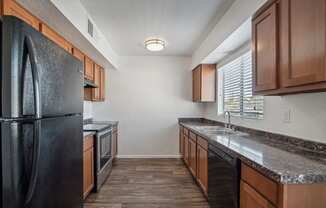the kitchen of our studio apartment atrium with stainless steel appliances and wooden cabinets