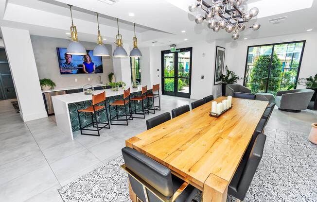 a dining room with a long wooden table and black chairs