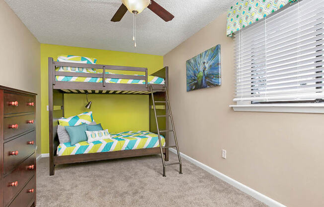 a bedroom with a bunk bed and a ceiling fan