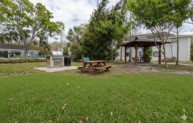 A picnic table sits in the middle of a grassy area.