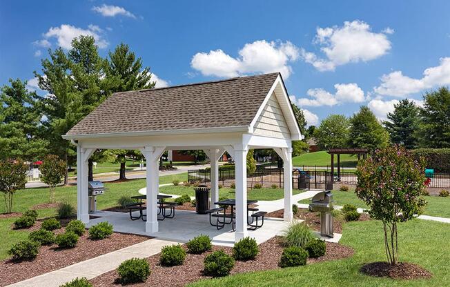 a pavilion with picnic tables in a park