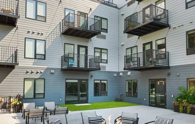 a fire pit in the middle of an outdoor patio in front of an apartment building
