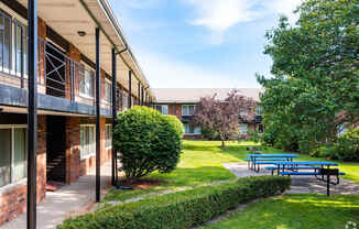 a patio with a blue picnic table in front of a building