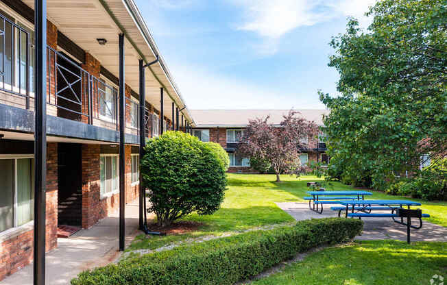 a patio with a blue picnic table in front of a building