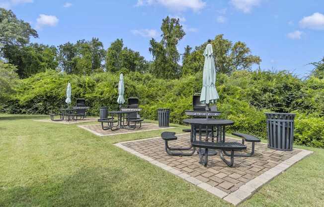 a patio with tables and umbrellas in a park