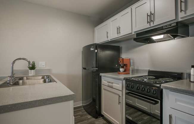 a kitchen with white cabinets and stainless steel appliances and a sink