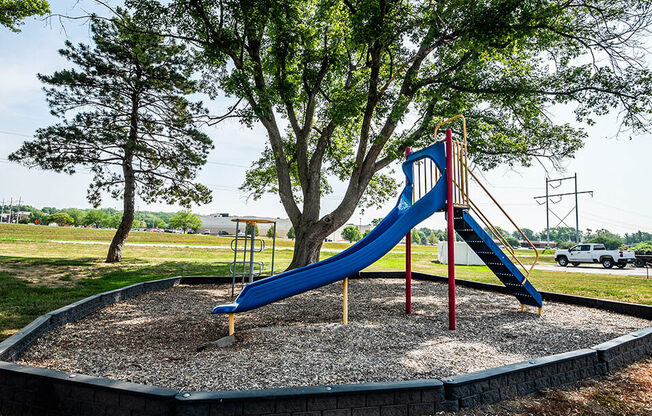 a playground with a blue slide and monkey bars