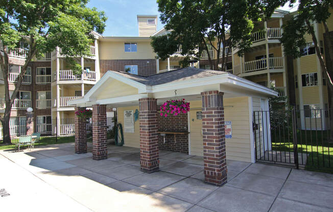 an outside view of an apartment building with a driveway and a gate