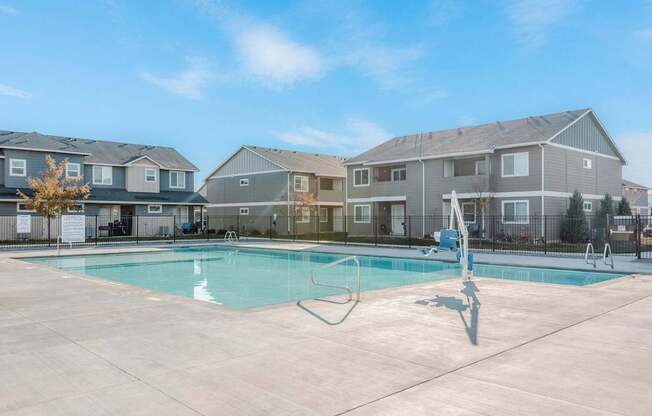 a swimming pool with apartment buildings in the background