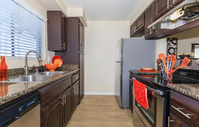 a large kitchen with stainless steel appliances and wooden cabinets