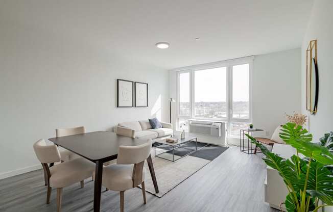 a living room and dining room with a table and chairs