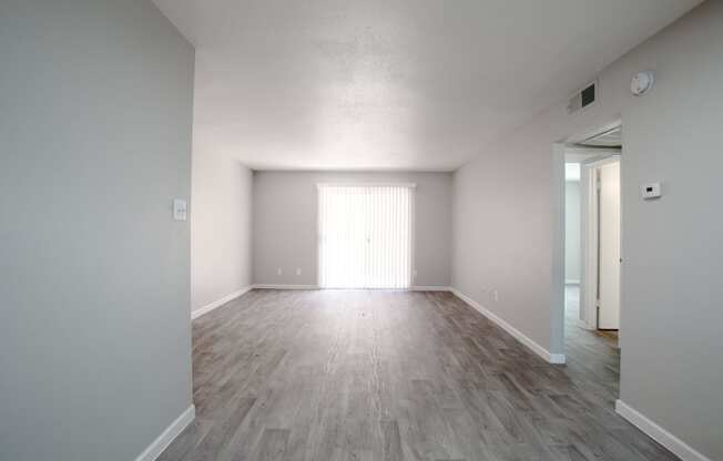 an empty living room with white walls and wood flooring