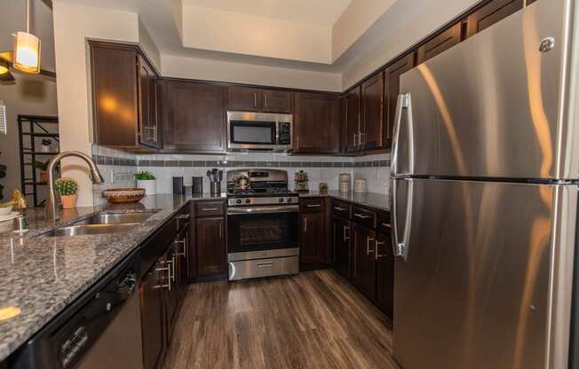 Kitchen with appliances and wooden cabinets at Level 25 at Cactus by Picerne, Las Vegas, NV