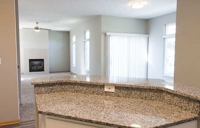 Granite island countertop with open-concept dining living room at Cascade Pines Town-homes Lincoln Nebraska