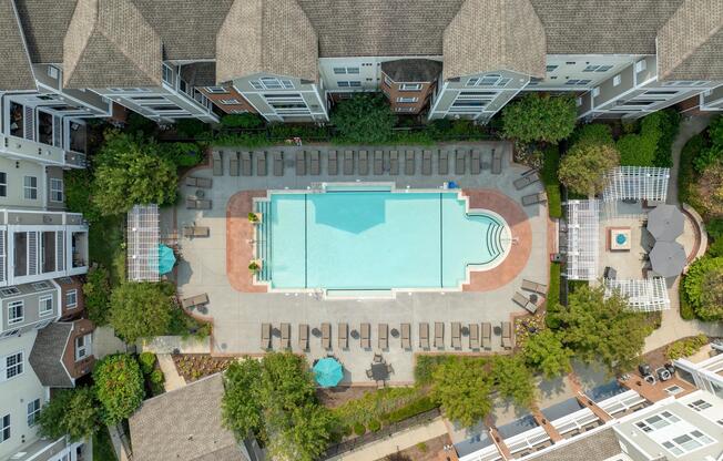 Aerial view of the pool courtyard highlights generous lounge areas, landscaped gathering spaces, and the community’s thoughtfully designed outdoor centerpiece.