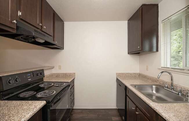 A kitchen with a black stove top oven and a counter top at Pepperwood Apartments, California, 95661