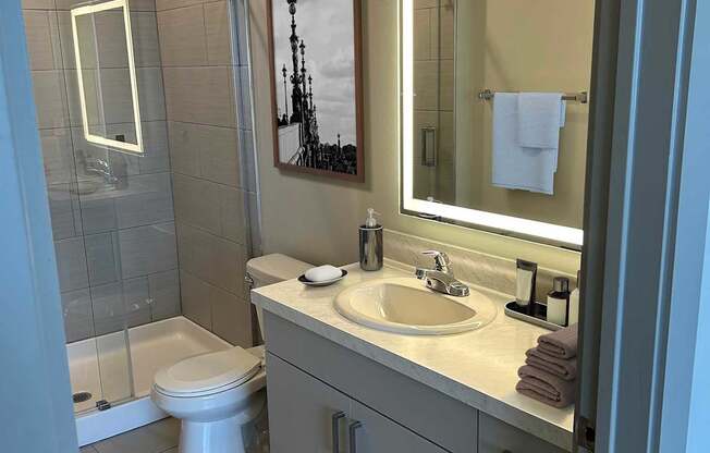 A bathroom with a toilet, sink, and mirror.