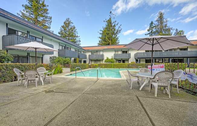 a swimming pool with tables and chairs and umbrellas