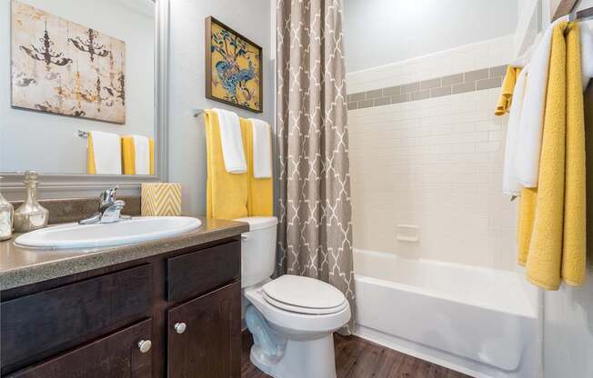 A bathroom with a white toilet, sink, and bathtub.