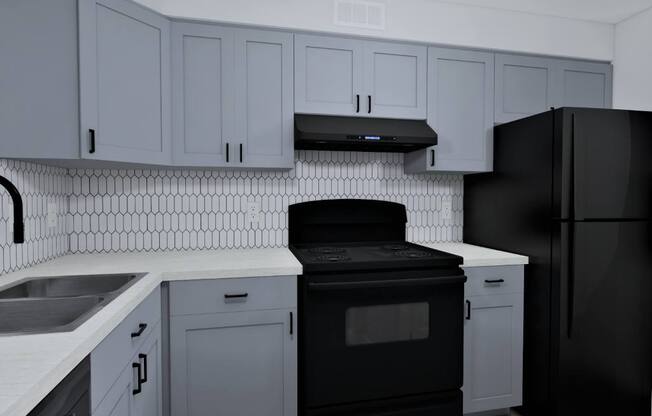 a kitchen with white cabinets and a black stove and refrigerator