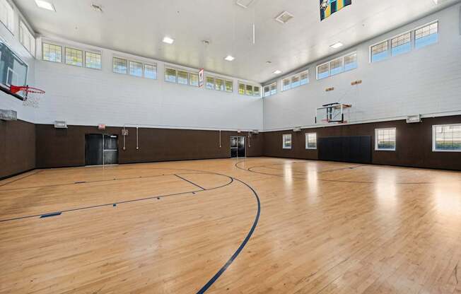 the gym has a hard wood floor and a basketball court