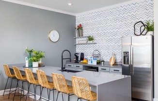 a kitchen with a large island and yellow chairs