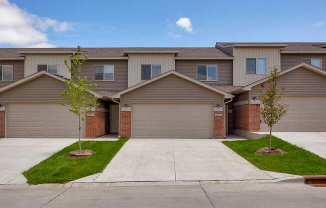 A row of houses with garages and driveways.