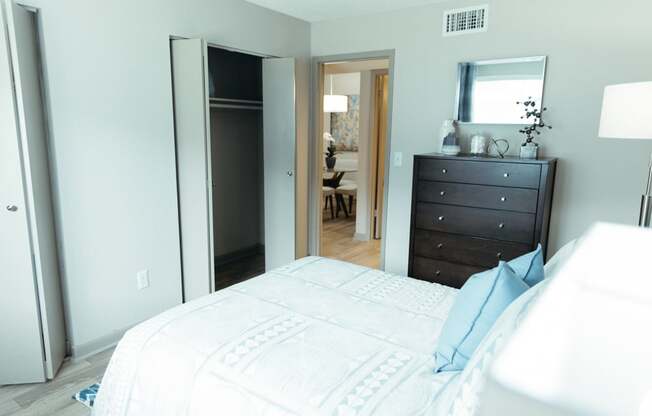 a bedroom with a bed and a dresser and a mirror