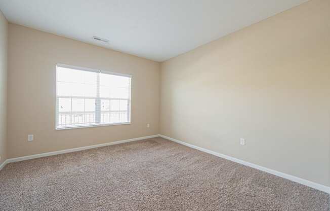 an empty room with carpet and a window