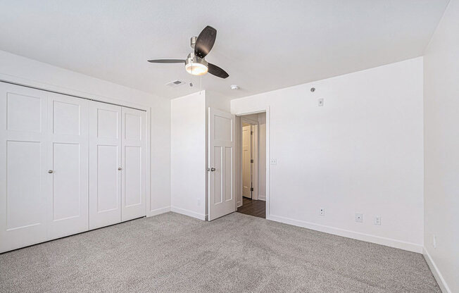 bedroom with a ceiling fan and large closet at Trade Winds Apartment Homes, Elkhorn, Nebraska