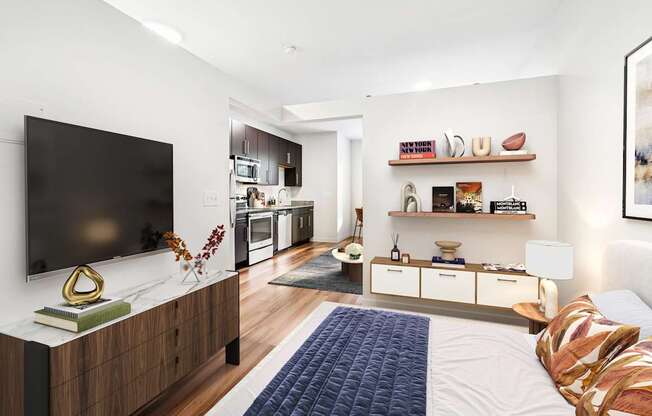 A modern bedroom with a large bed and a flat screen TV on the wall.