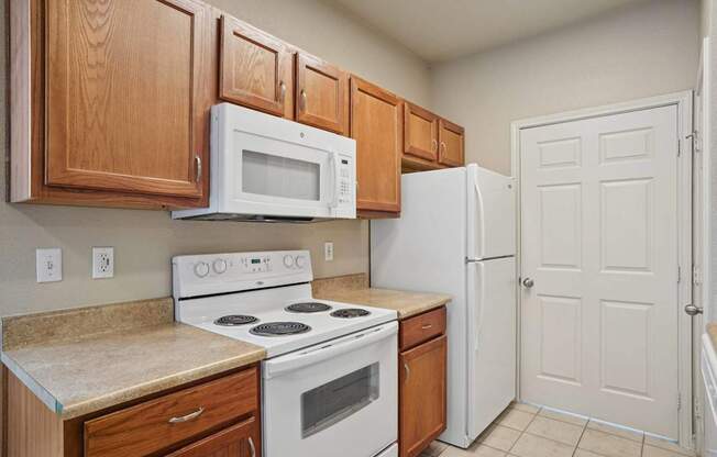 A kitchen with a white stove and white refrigerator.