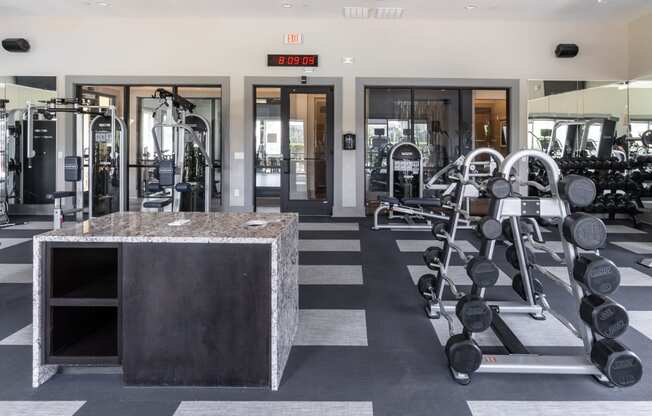 a view of the fitness center with weights machines and mirrors
