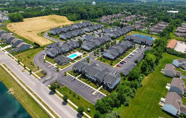 A bird's eye view of a residential area with houses and a swimming pool.