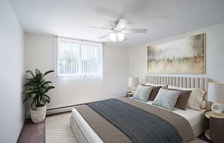 a bedroom with a bed and a ceiling fan. Coon Rapids, MN Robinwood Apartments