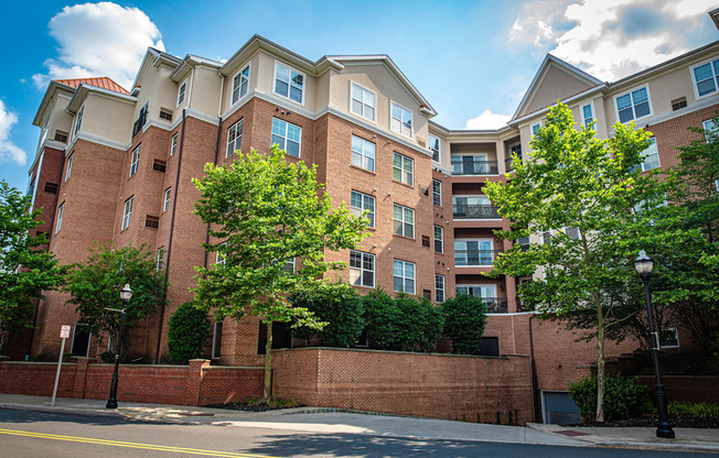 a red brick apartment building with trees in front of it at Park Square Apartments, Rahway, 07065