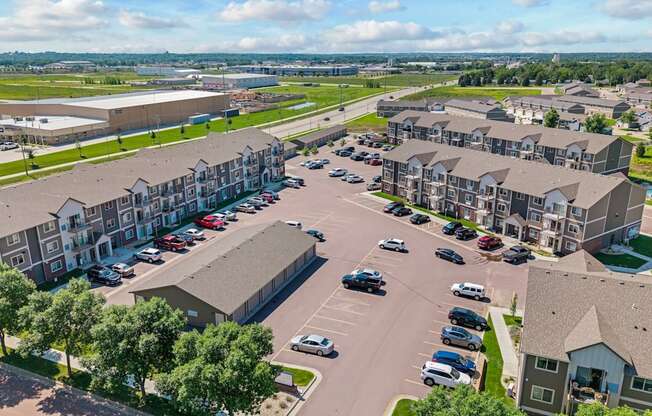 A large parking lot is surrounded by apartment buildings.
