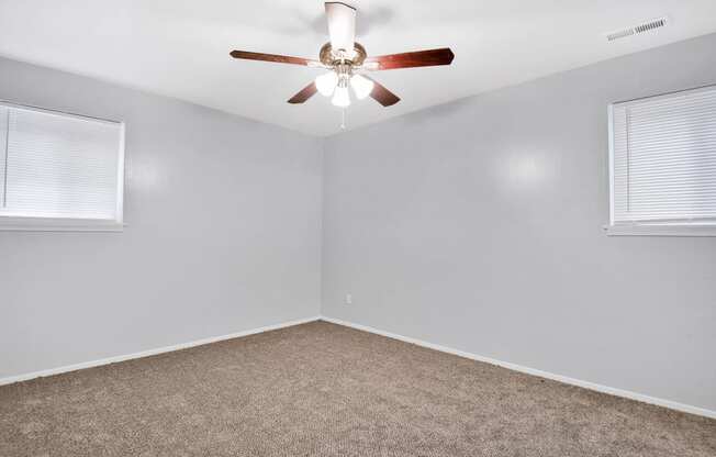 large carpeted room with ceiling fan