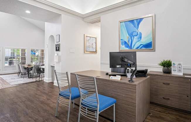 Leasing office with staff desk and two blue chairs at La Costa in Plano, TX