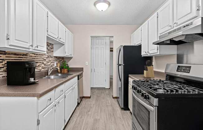 A kitchen with black appliances and white cabinets.