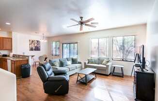 A living room with a black leather chair and a white couch.