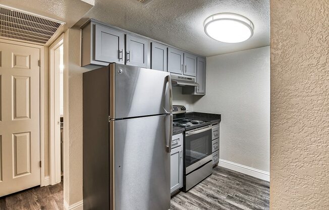 a kitchen with white cabinets and stainless steel appliances