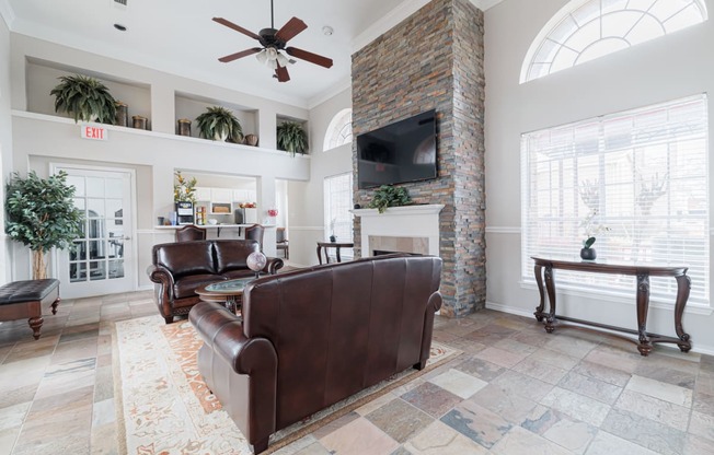 a living room with leather furniture and a brick fireplace