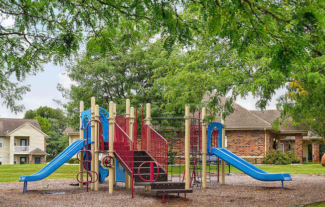 A playground with a blue slide and a red slide.