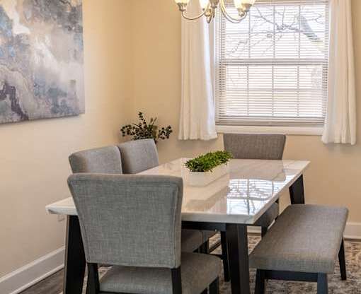 A dining room with a table and chairs.