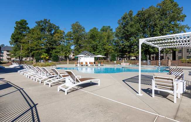 A pool area with sun loungers and a white canopy.