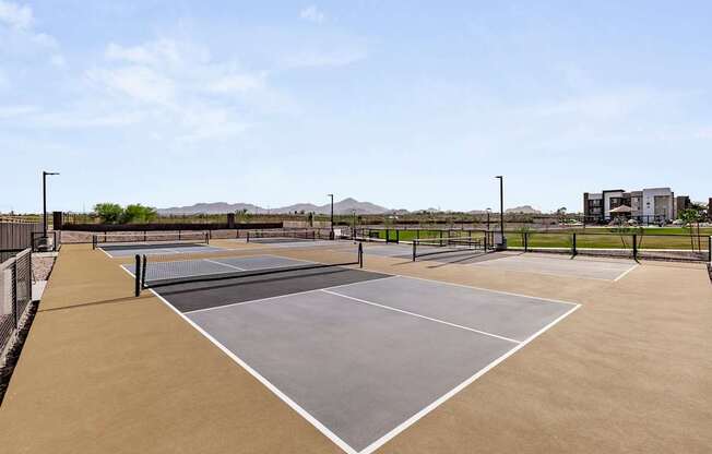 A tennis court with a net and two courtside buildings.