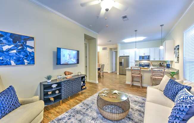 a living room and kitchen with a flat screen tv and a coffee table